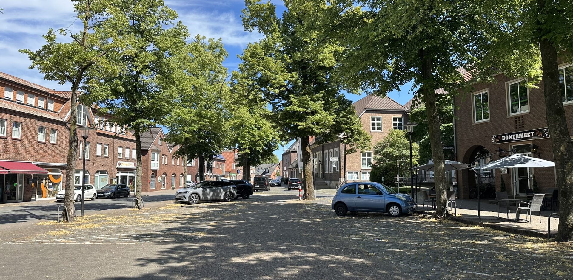 Ein Marktplatz mit Parkplätzen und Bäumen.